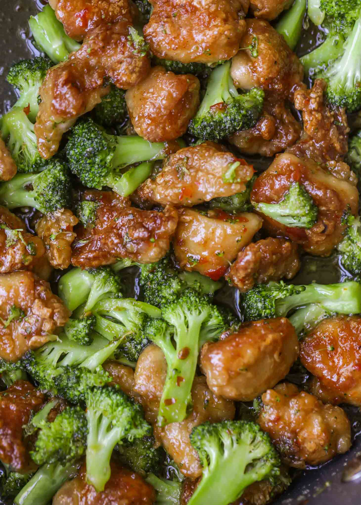 A close up of chicken and broccoli cooking in a pan.