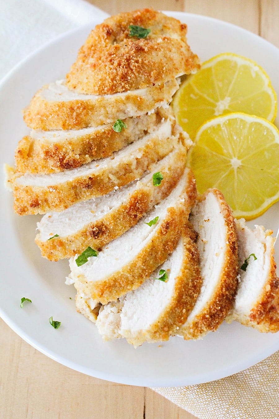 Close up of baked parmesan crusted chicken cut into slices