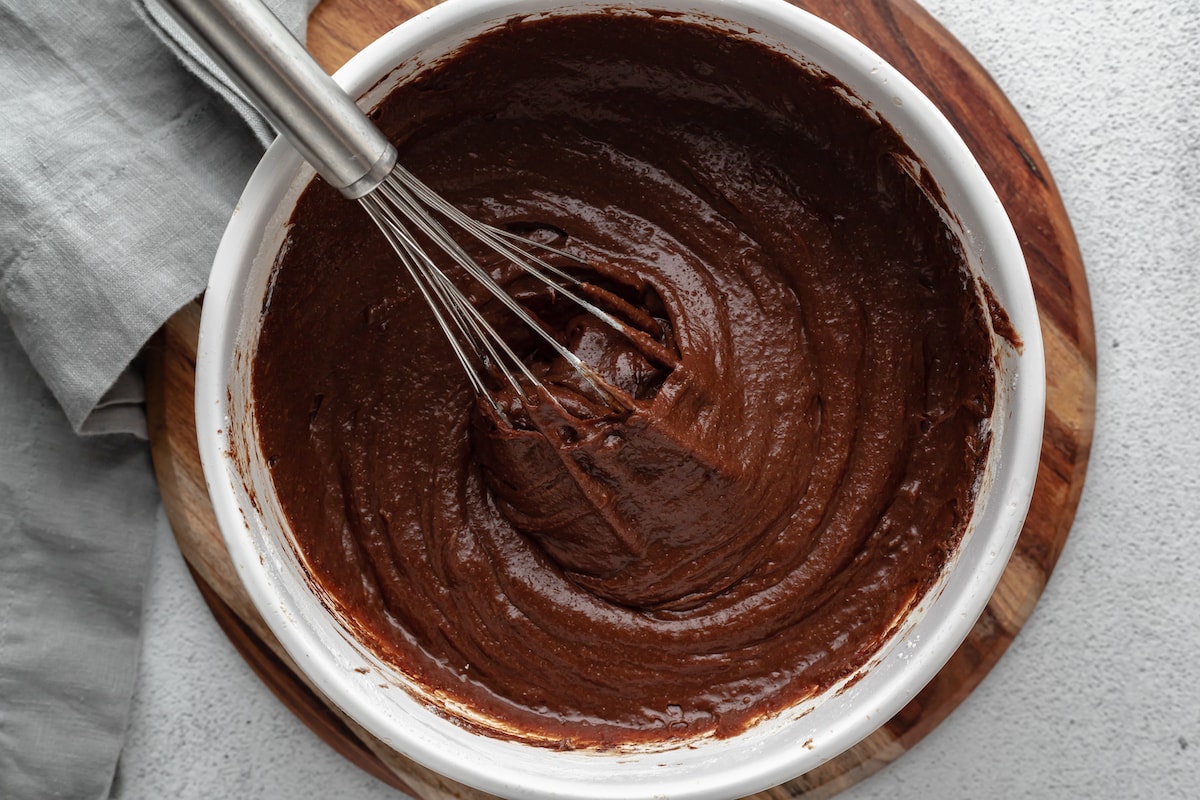 Brownie batter is whisked together in a mixing bowl.