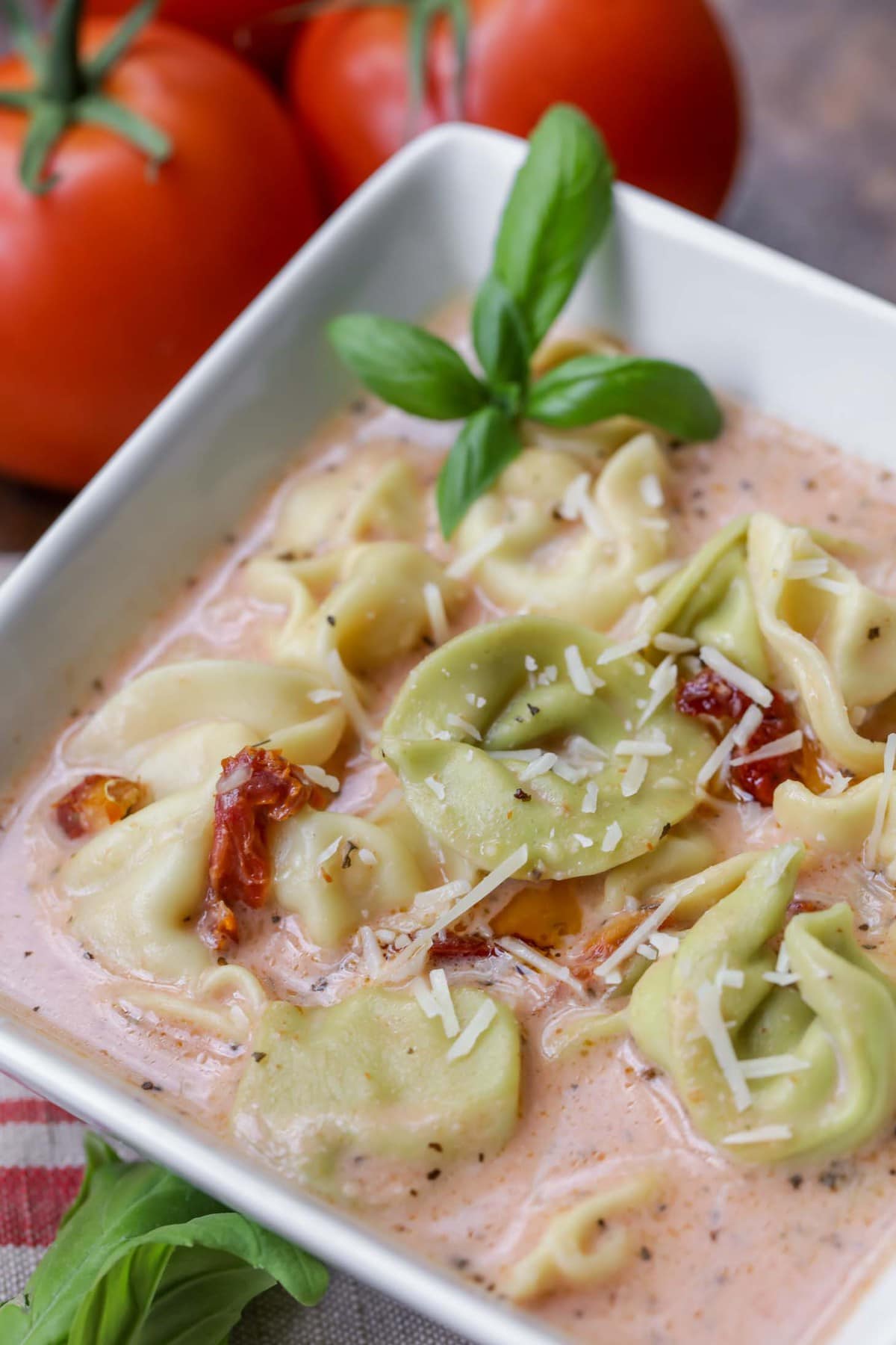 Italian Soups - Tomato tortellini soup served with fresh herbs and grated parmesan.