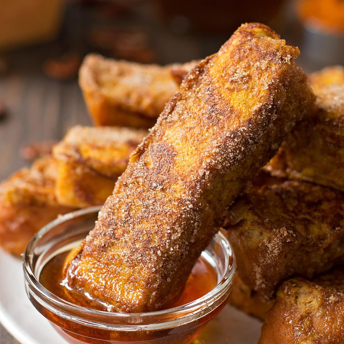 Pumpkin French Toast Sticks being dipped in syrup