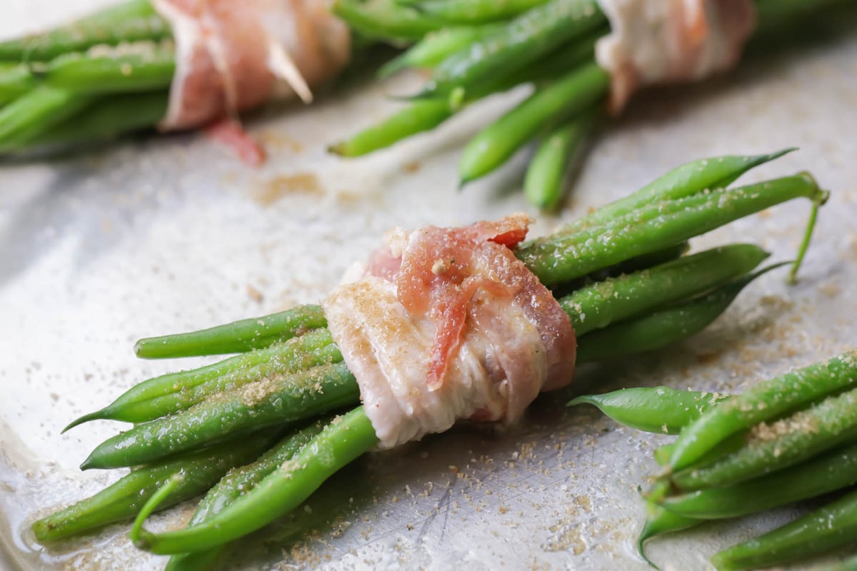 Green beans wrapped in bacon ready to be baked.