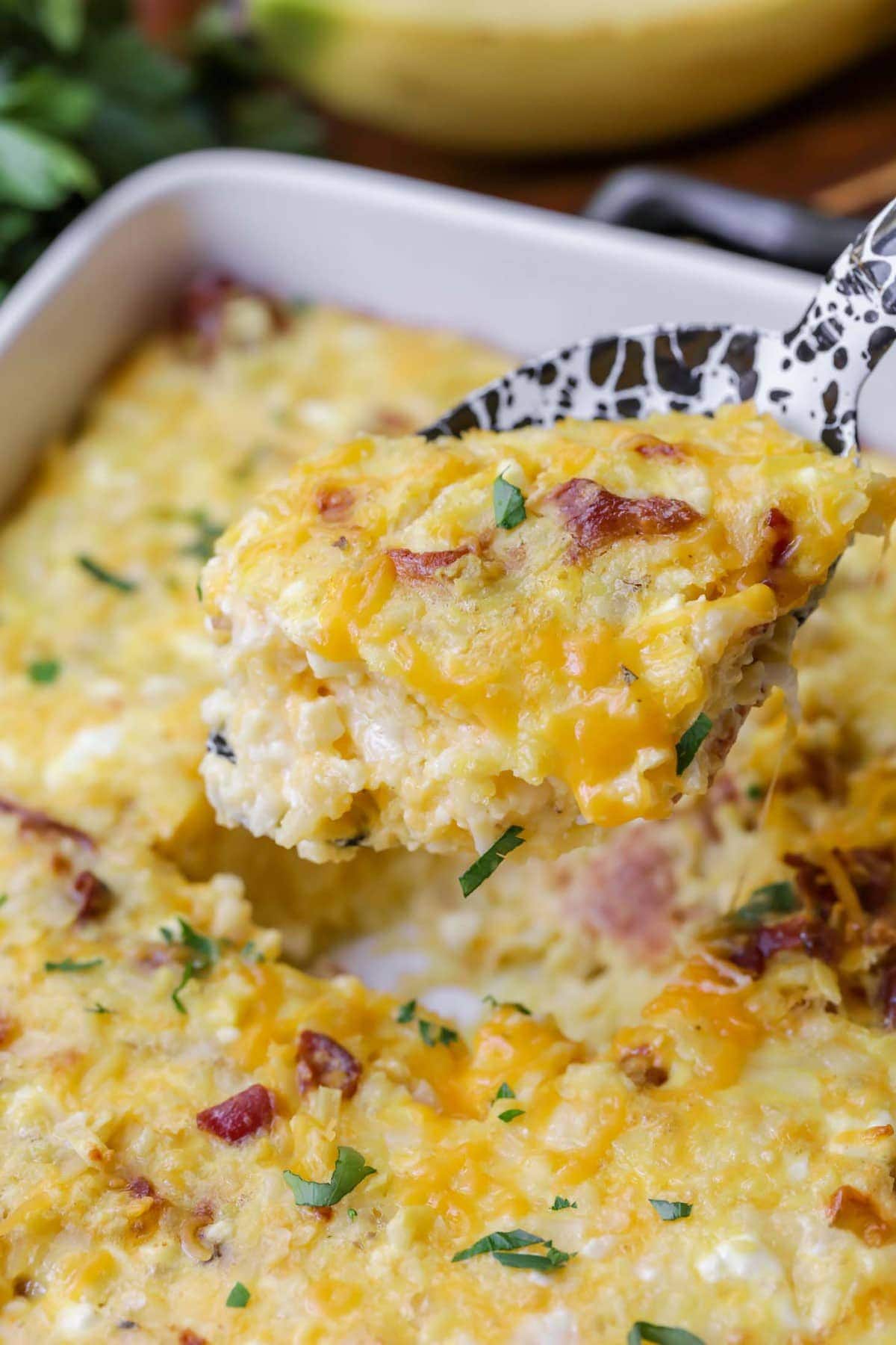 Cheesy Breakfast Hashbrown Casserole scooped out on a spoon.