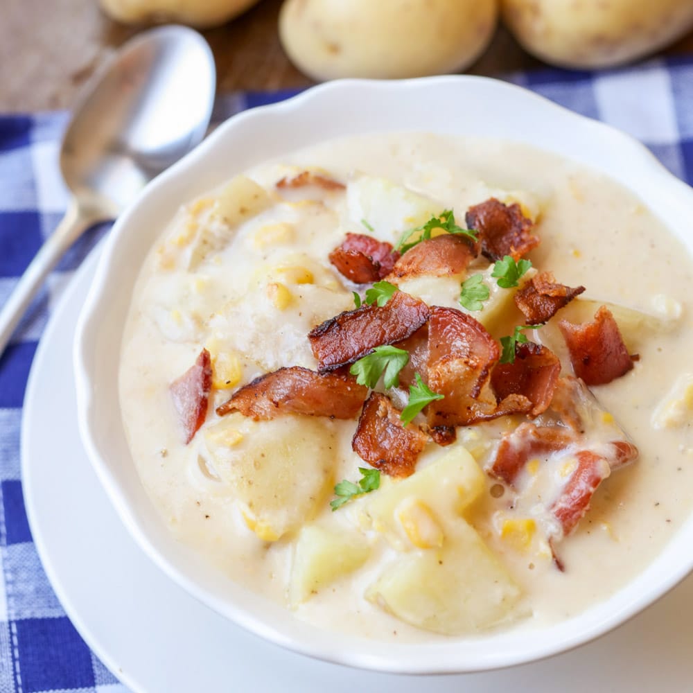Easy soup recipes - Bacon potato corn chowder topped with bacon bits and parsley in a white bowl.