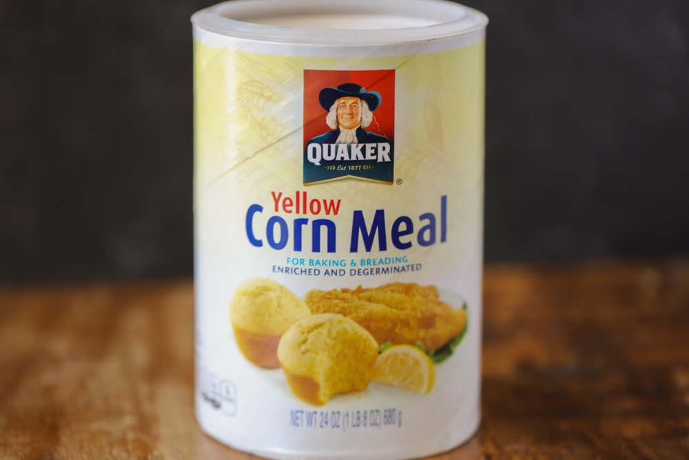 A canister of corn meal on a kitchen table.