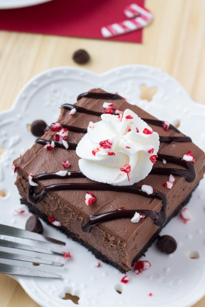 slice of no bake chocolate cheesecake on plate with crushed candy canes