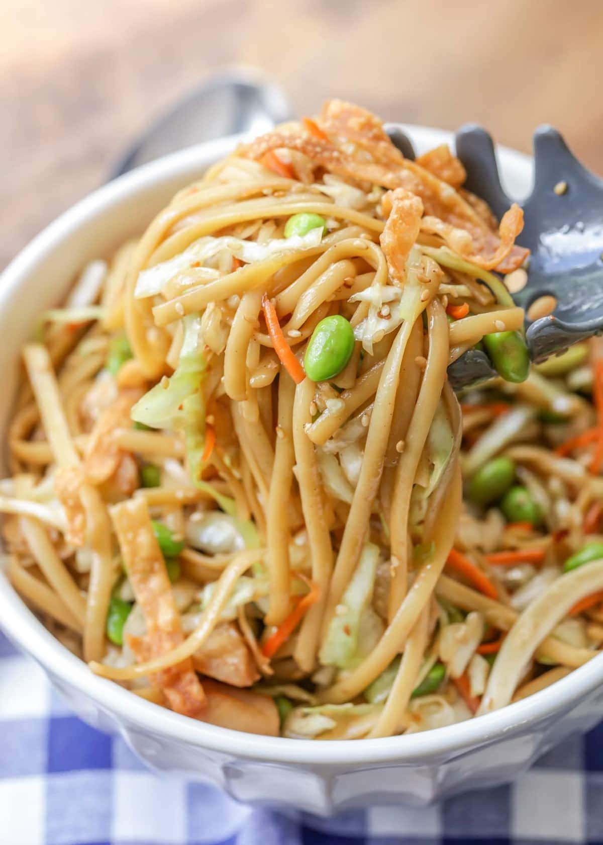 Asian noodle salad recipe in white bowl with edamame