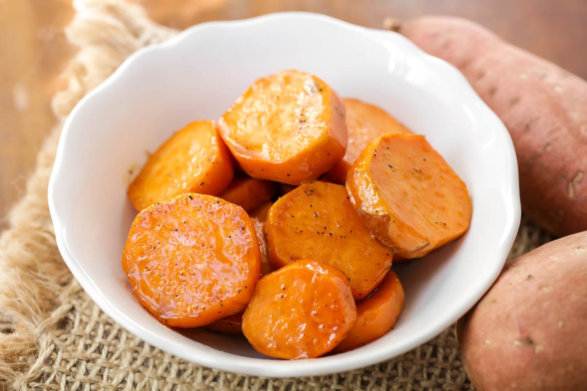 Easy side dishes - candied sweet potatoes piled in a white bowl.