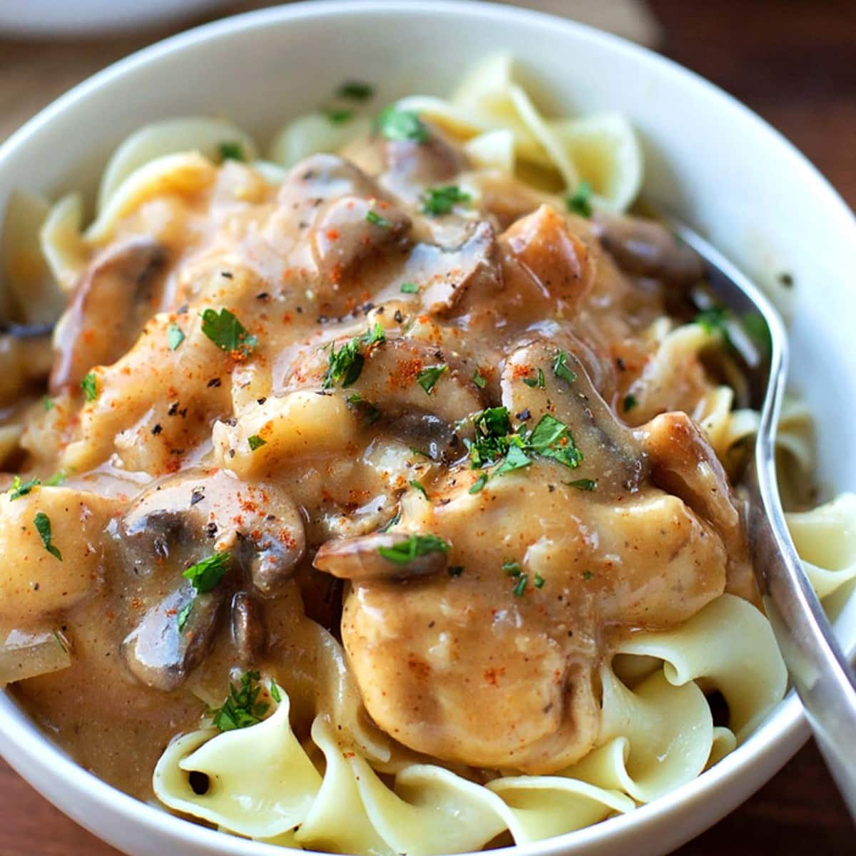 Chicken Stroganoff servido sobre uma tigela de massa de ovo