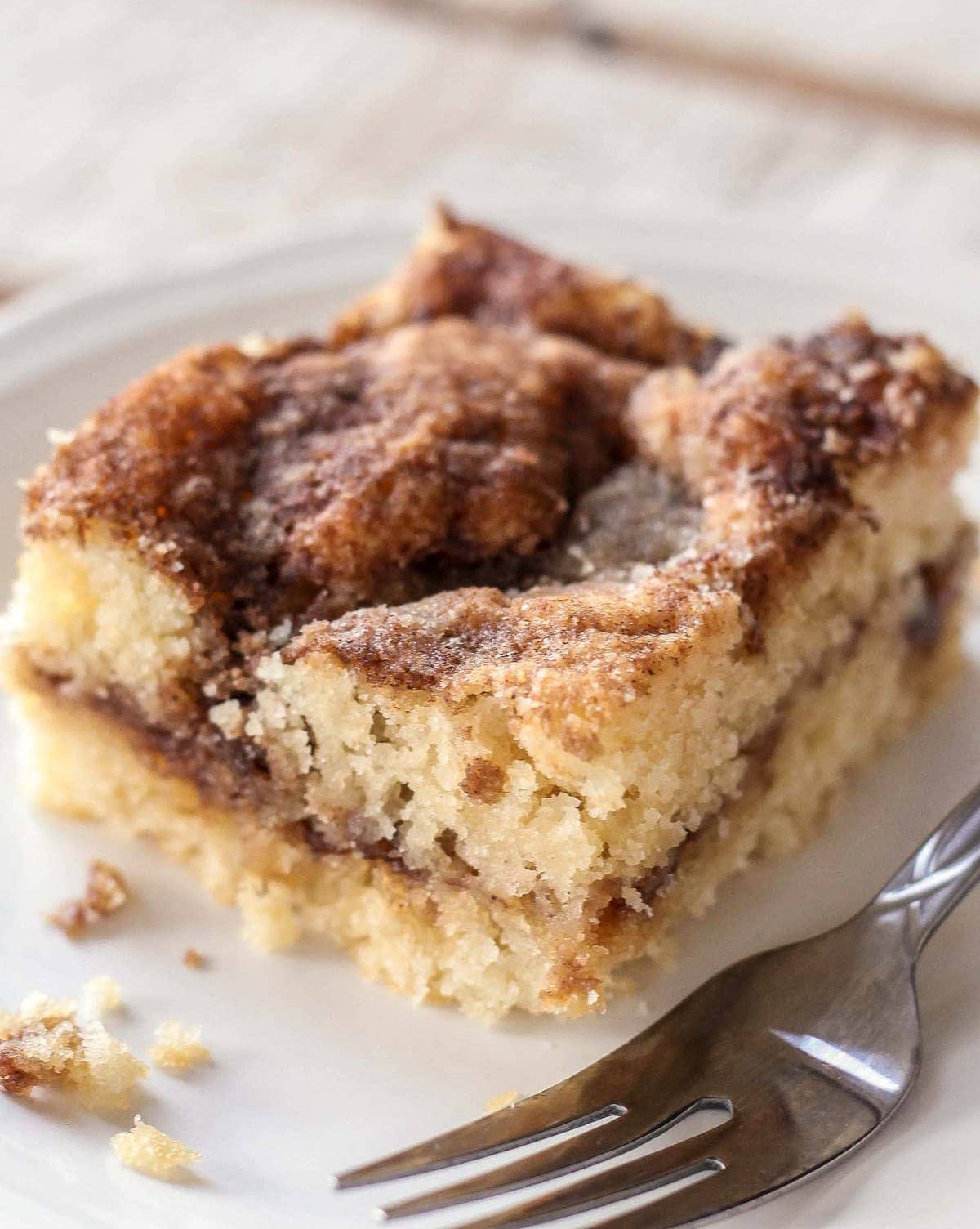 A square of crumbly homemade coffee cake served on a white plate.