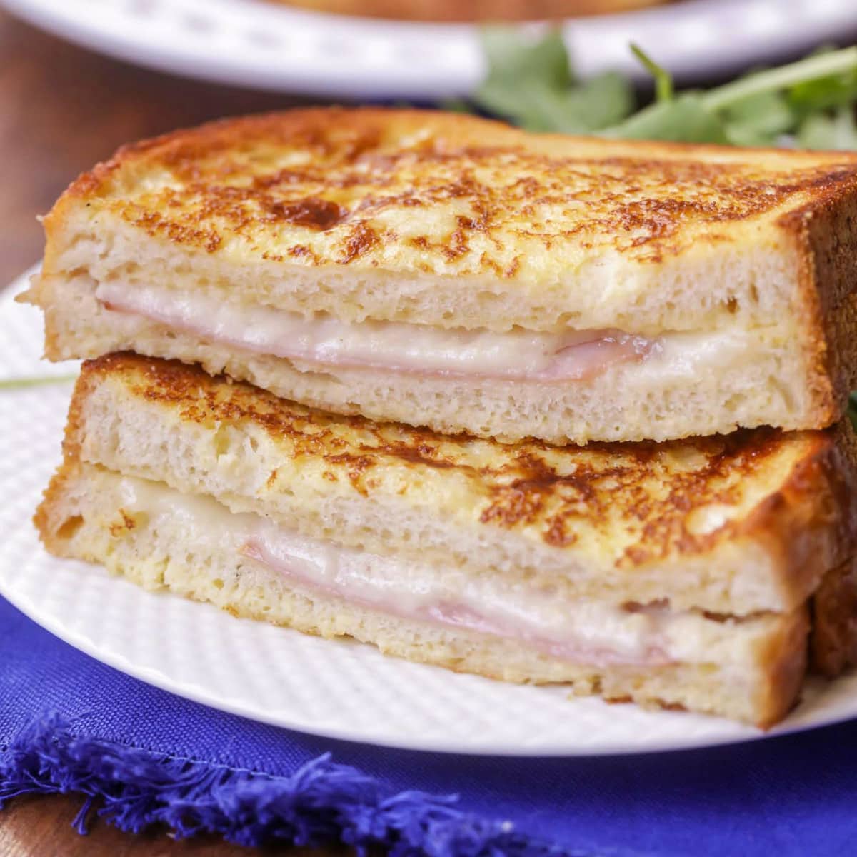 Croque Monsieur cut in half and placed on a white plate.