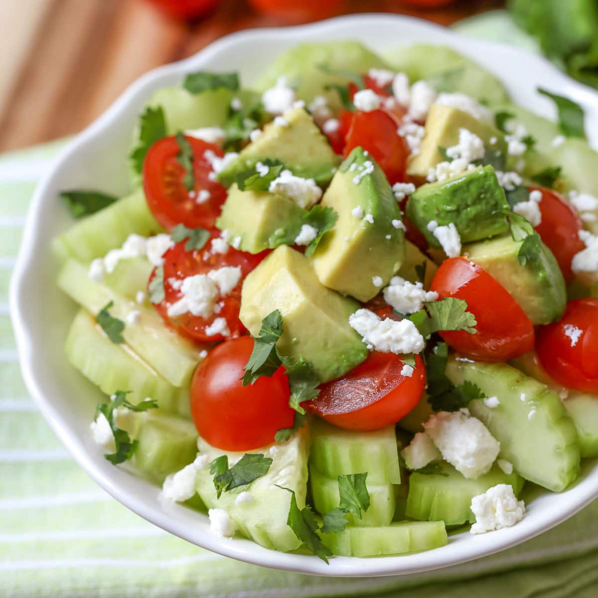 Vegetable side dishes - a bowl filled with cucumber tomato avocado salad.