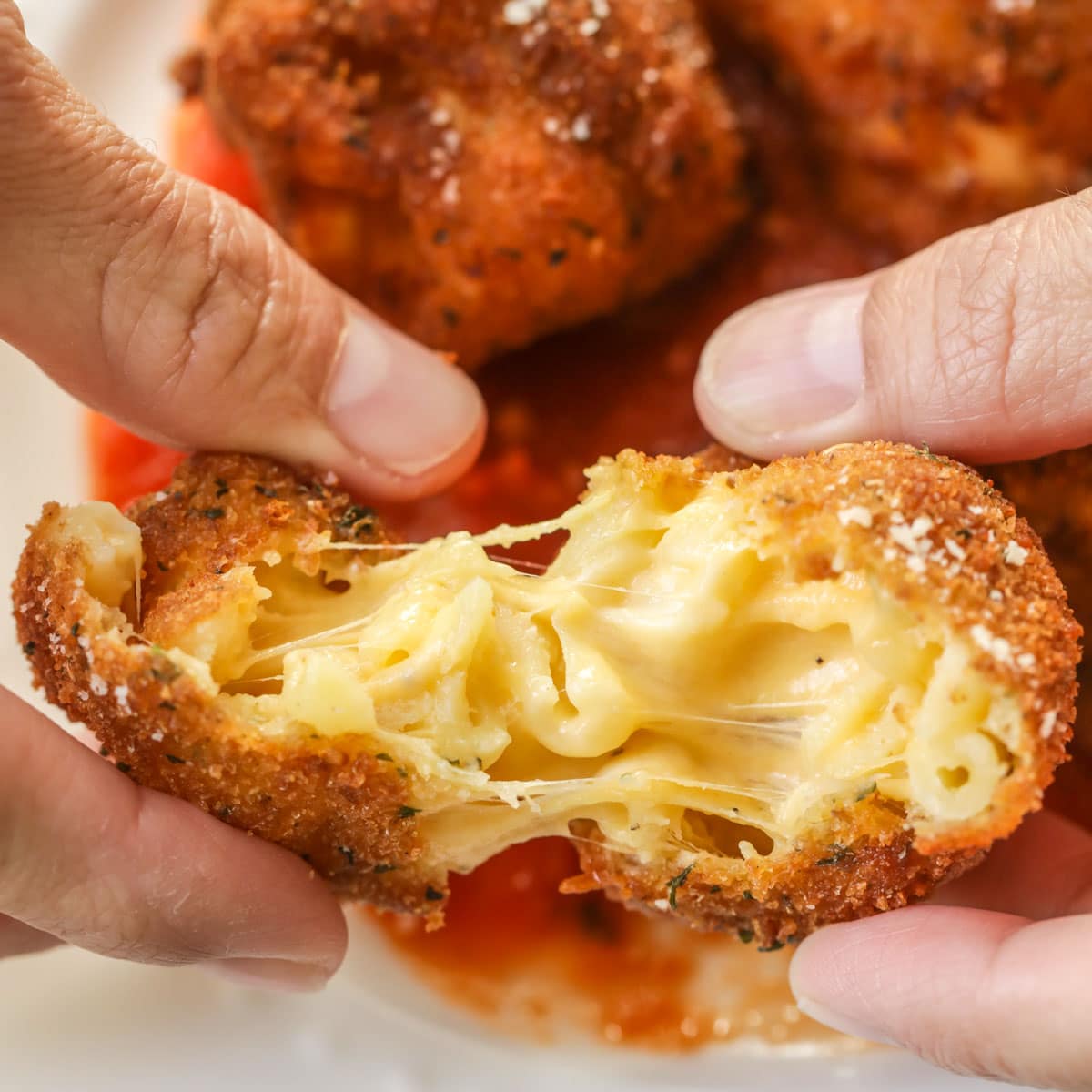 Halloween dinner ideas - pulling apart fried mac and cheese balls.