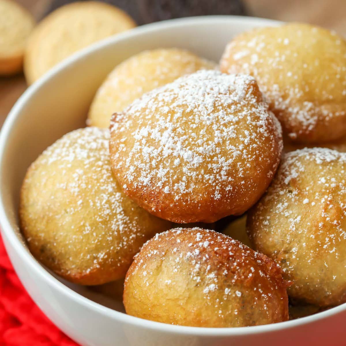 Fried Oreos topped with powder sugar, piled in bowl.
