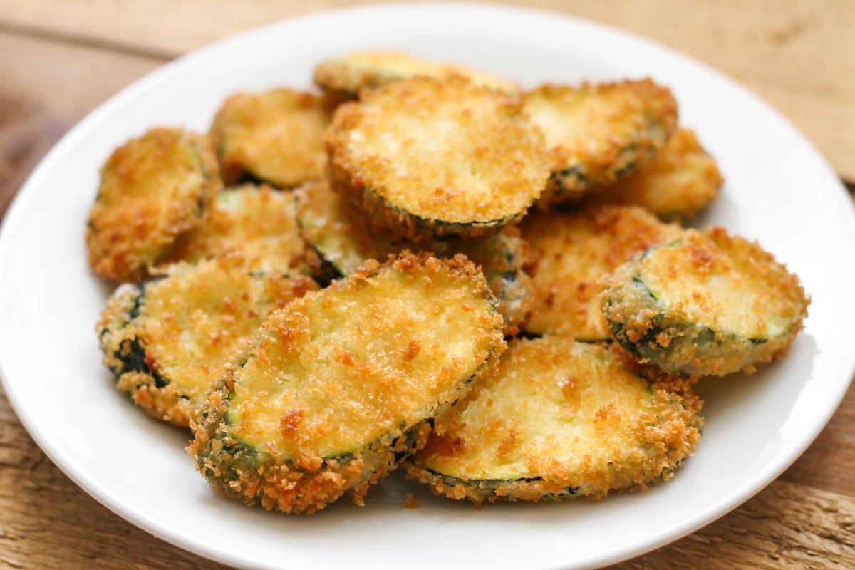 Fried zucchini slices on a white plate