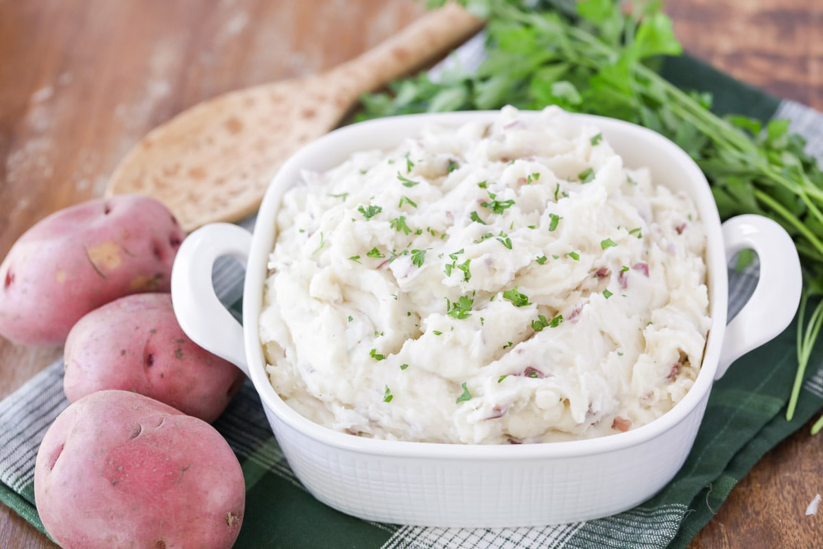 Vegetable side dishes - garlic mashed red potatoes served in a white baking dish.