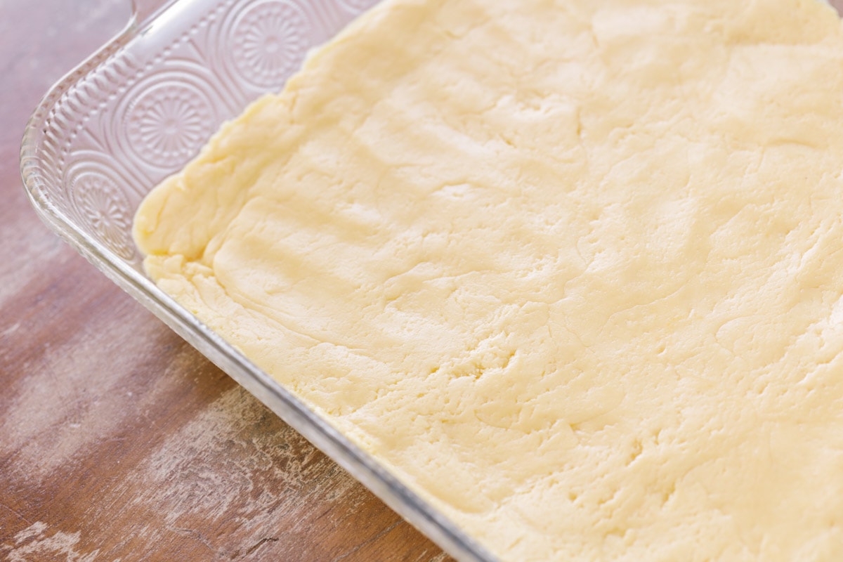 Ooey gooey butter cake crust in a glass baking dish