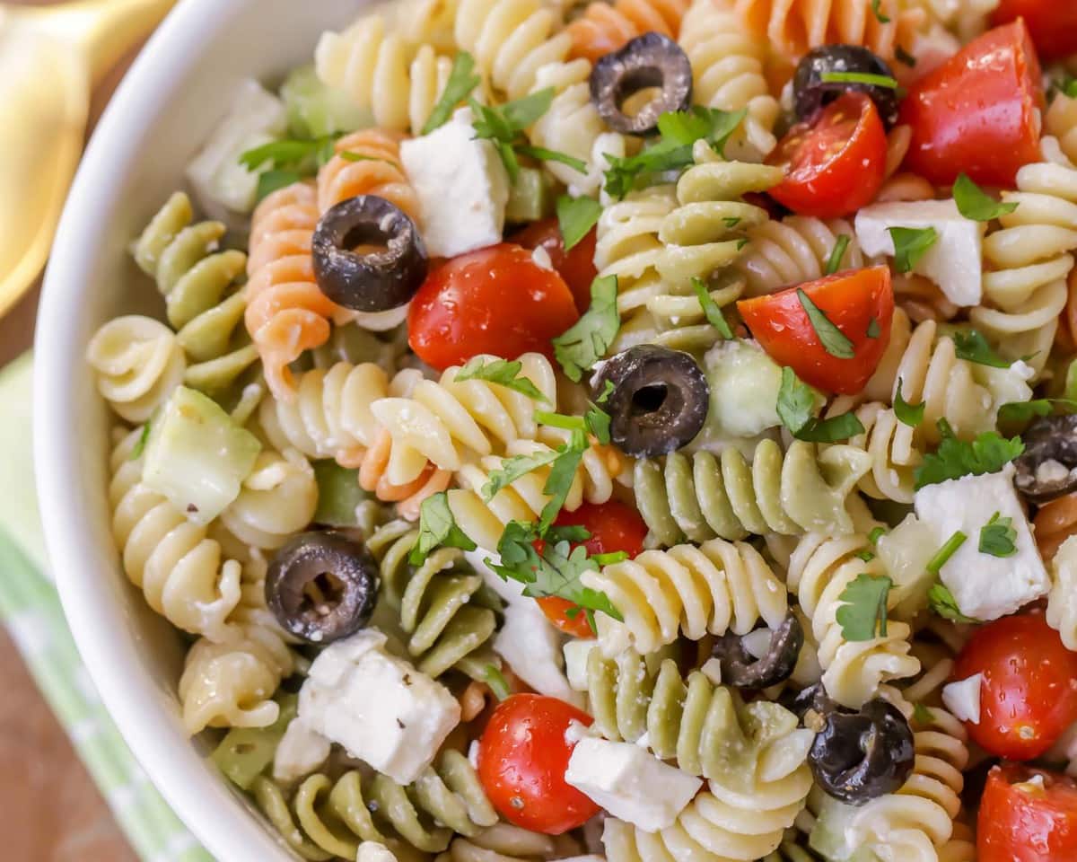 Fall salad recipes - close up of Greek pasta salad topped with tomatoes and olives.