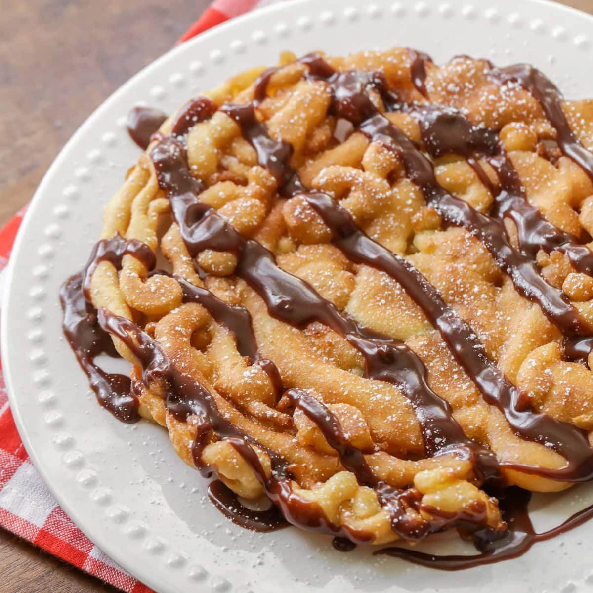 Funnel cake with chocolate sauce and powdered sugar.