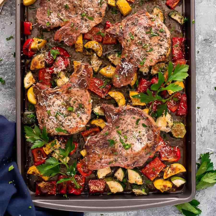 Italian style pork chops on a sheet pan with vegetables