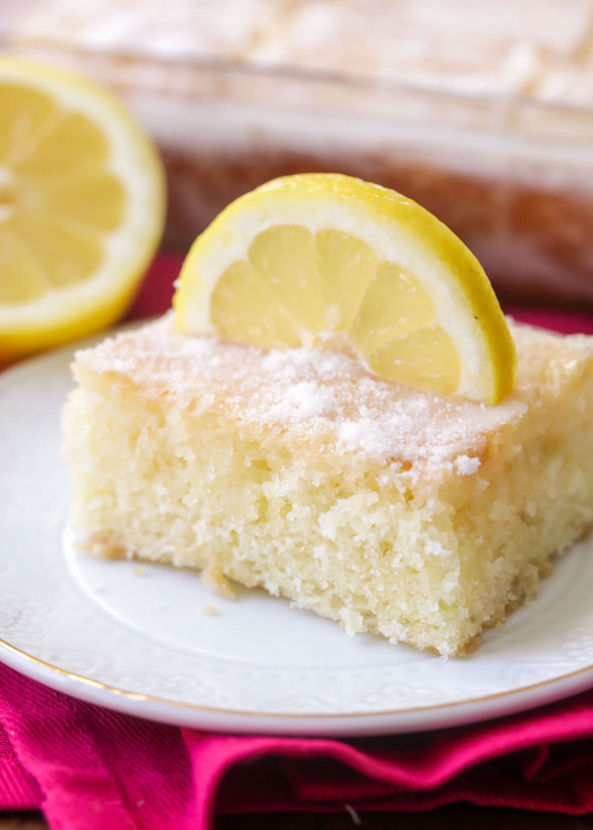 Lemon buttermilk cake garnished with a lemon displayed on a white plate.