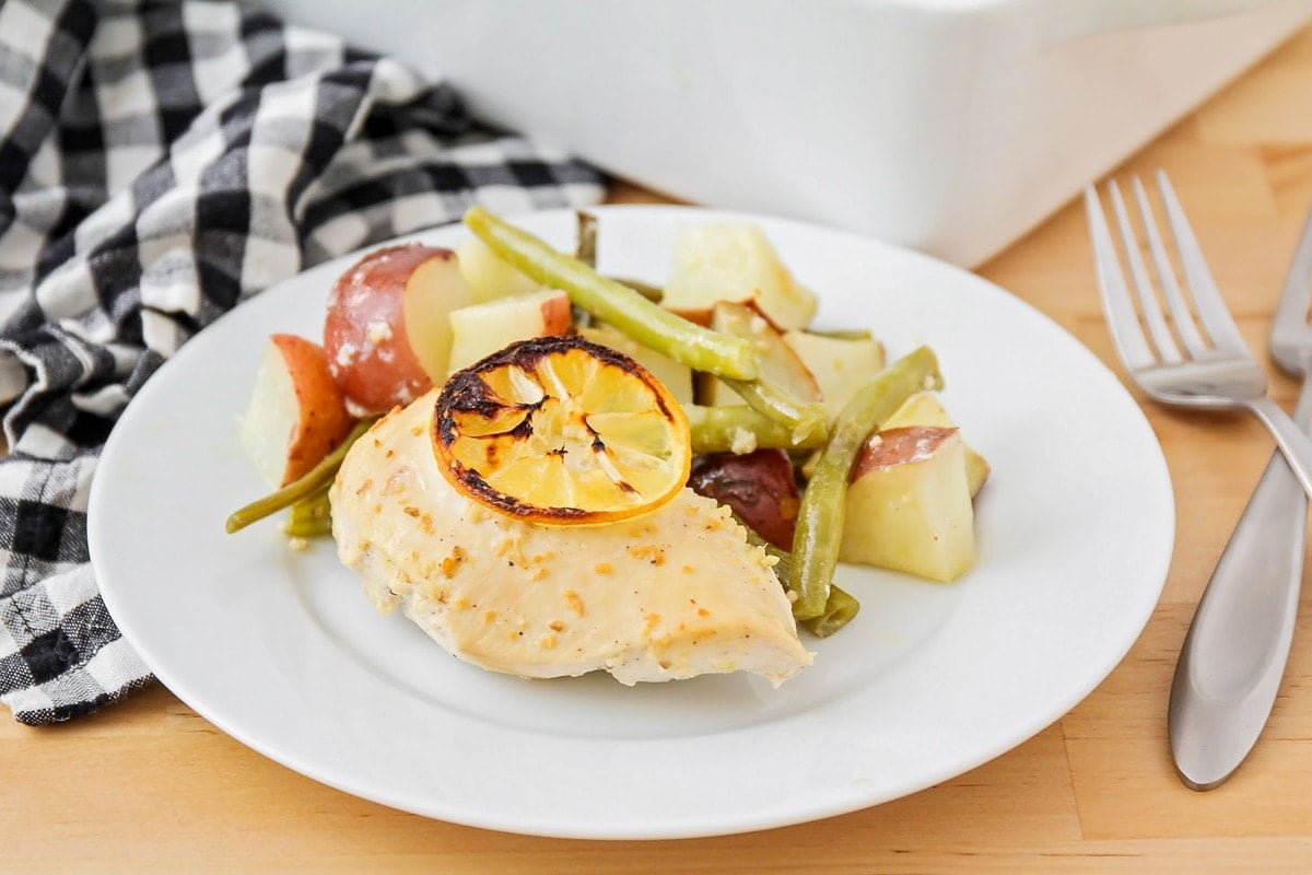 Chicken Breast Recipes - Lemon chicken with veggies served on a white plate with potatoes and green beans.