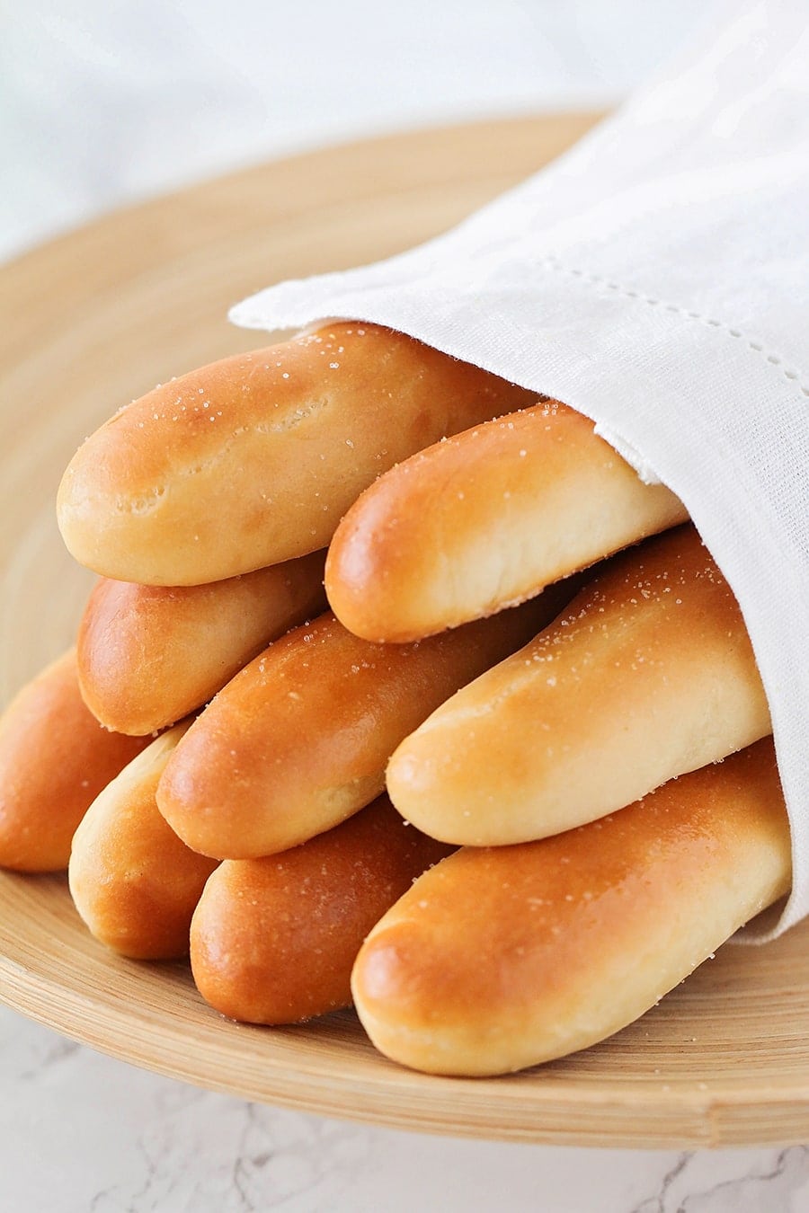 Italian Appetizers - Several Olive garden breadsticks in a white tea towel.