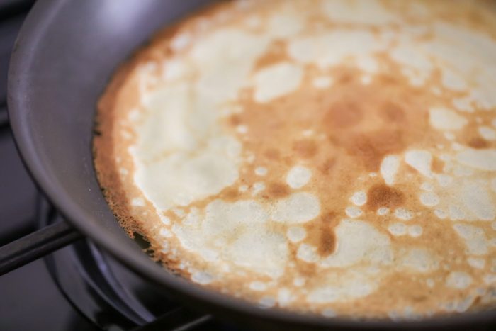Handed down for generations, this homemade Swedish pancakes recipe is the softest, most delicious. Add a sweet or savory filling! A browning Swedish pancake in a skillet.