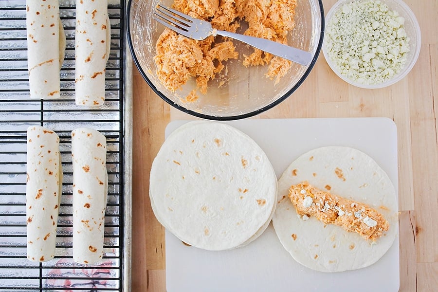 Rolling buffalo chicken mixture in tortillas