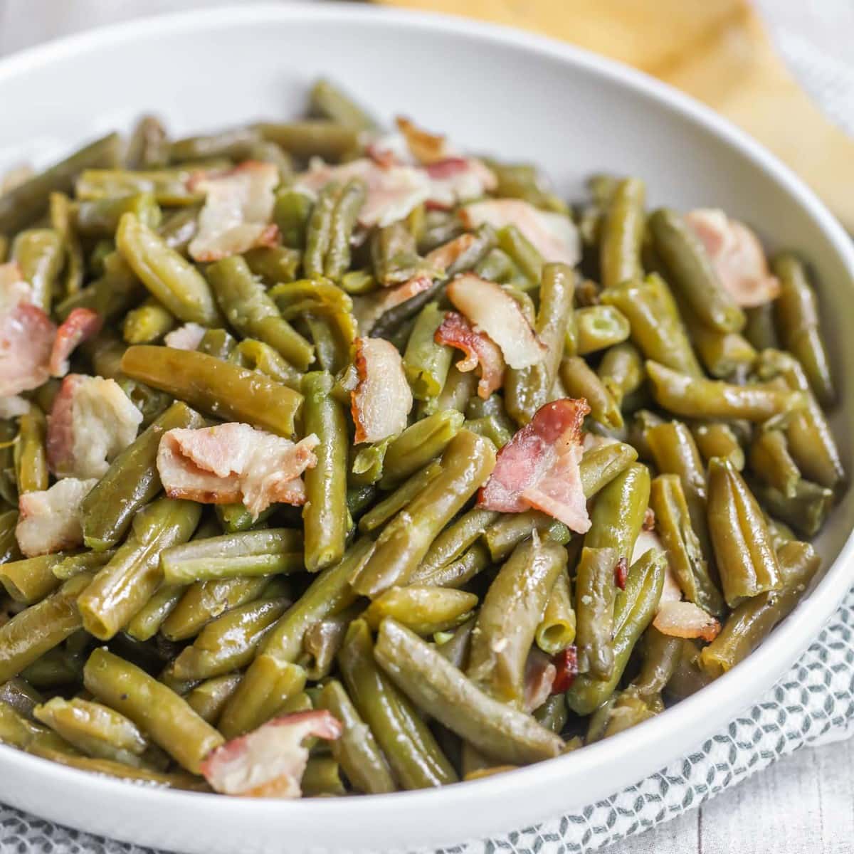 Green beans with bacon in a white bowl