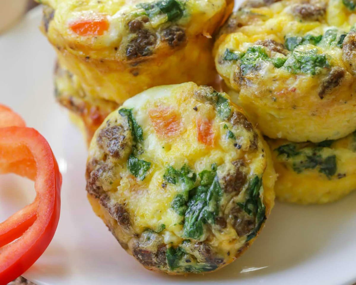 Breakfast for dinner - healthy egg muffins stacked on a white plate.