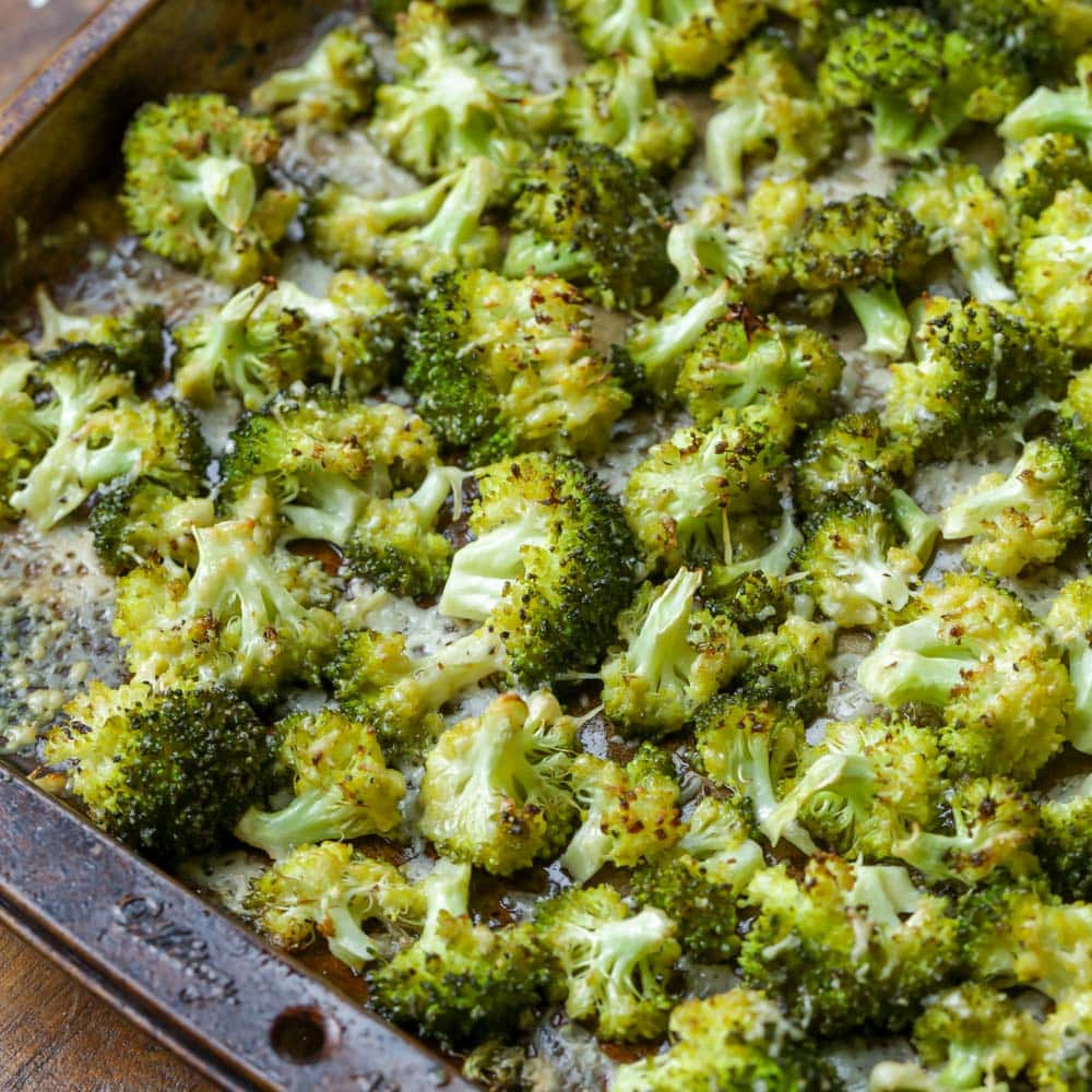 Thanksgiving side dishes - roasted broccoli spread on a baking sheet.