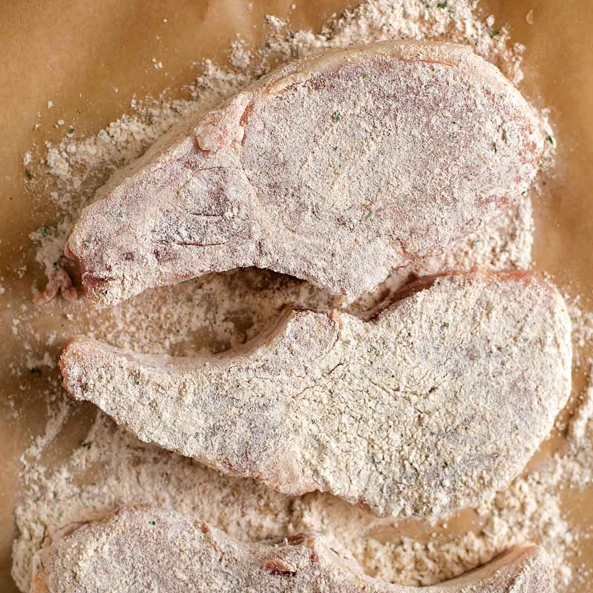 Breading pork chops in seasoned mixture