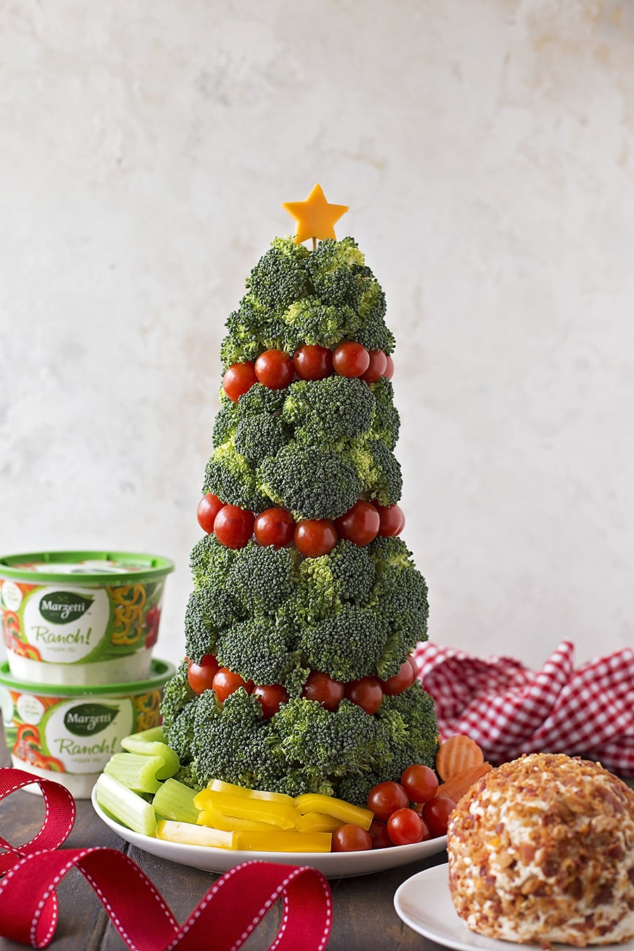 Veggie christmas tree on a plate with dips and a cheese ball