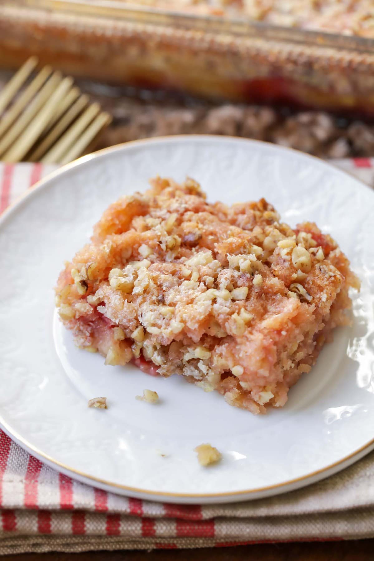 A square slice of cherry dump cake served on a white plate.