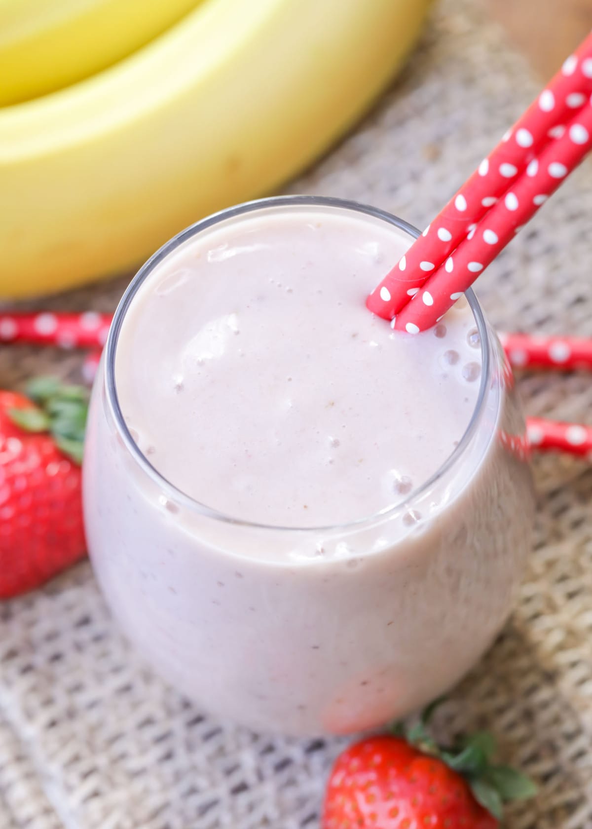 strawberry and banana smoothie in a cup with red straws