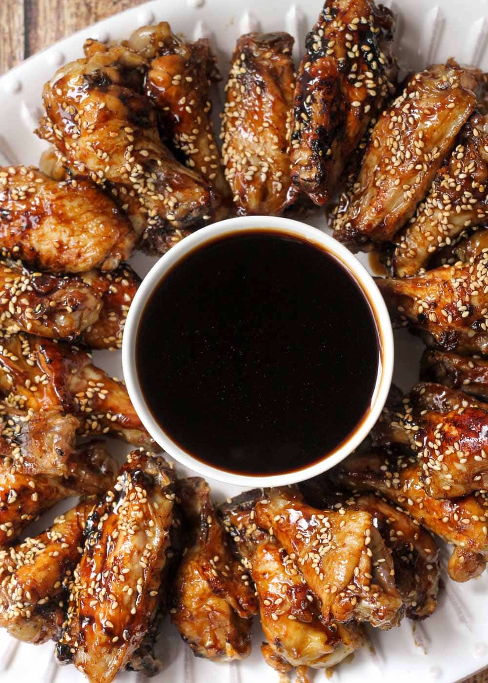 Buffalo wings - a plate of teriyaki chicken wings served with dipping sauce.