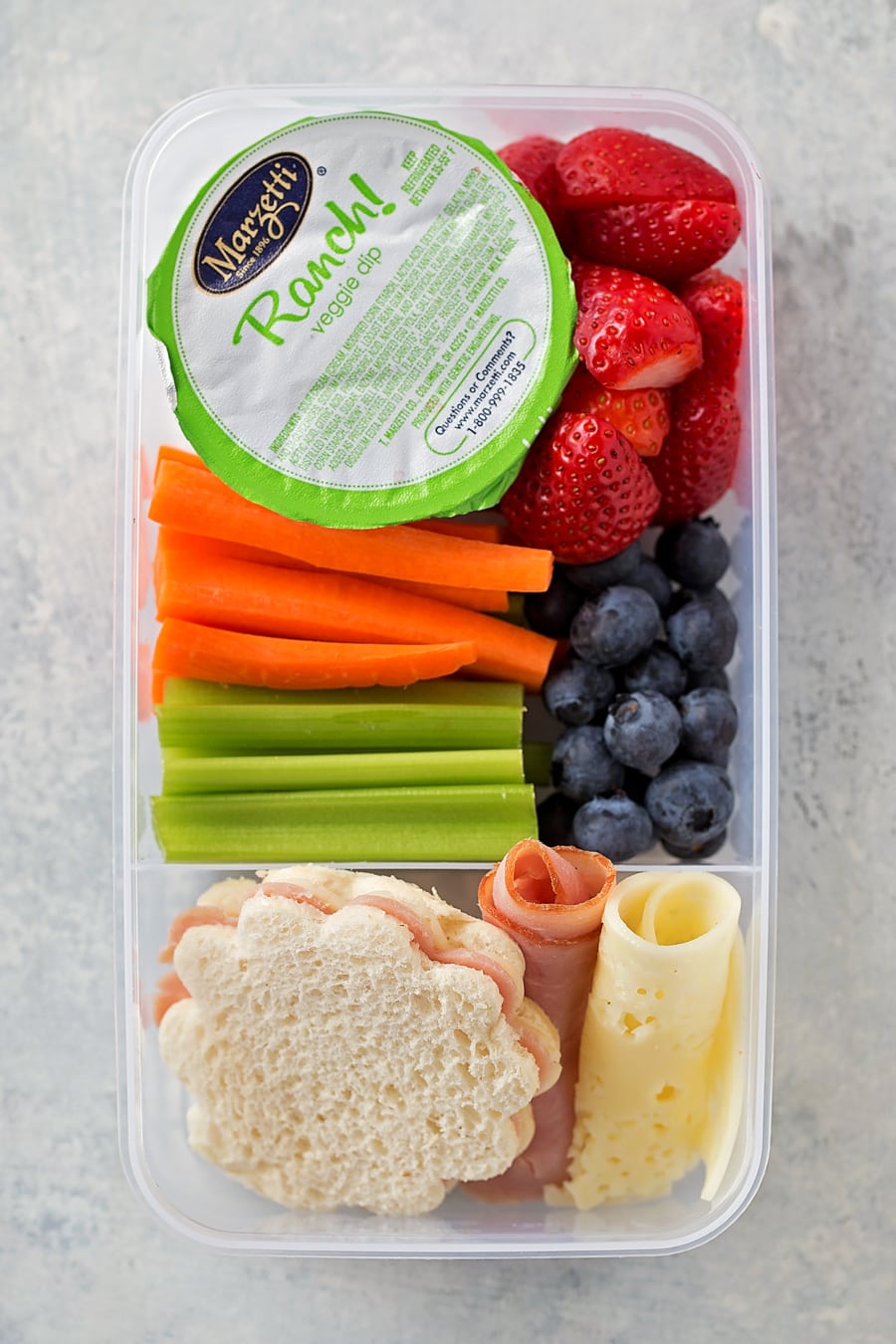 school lunch box idea with sandwich, berries, carrots, and celery