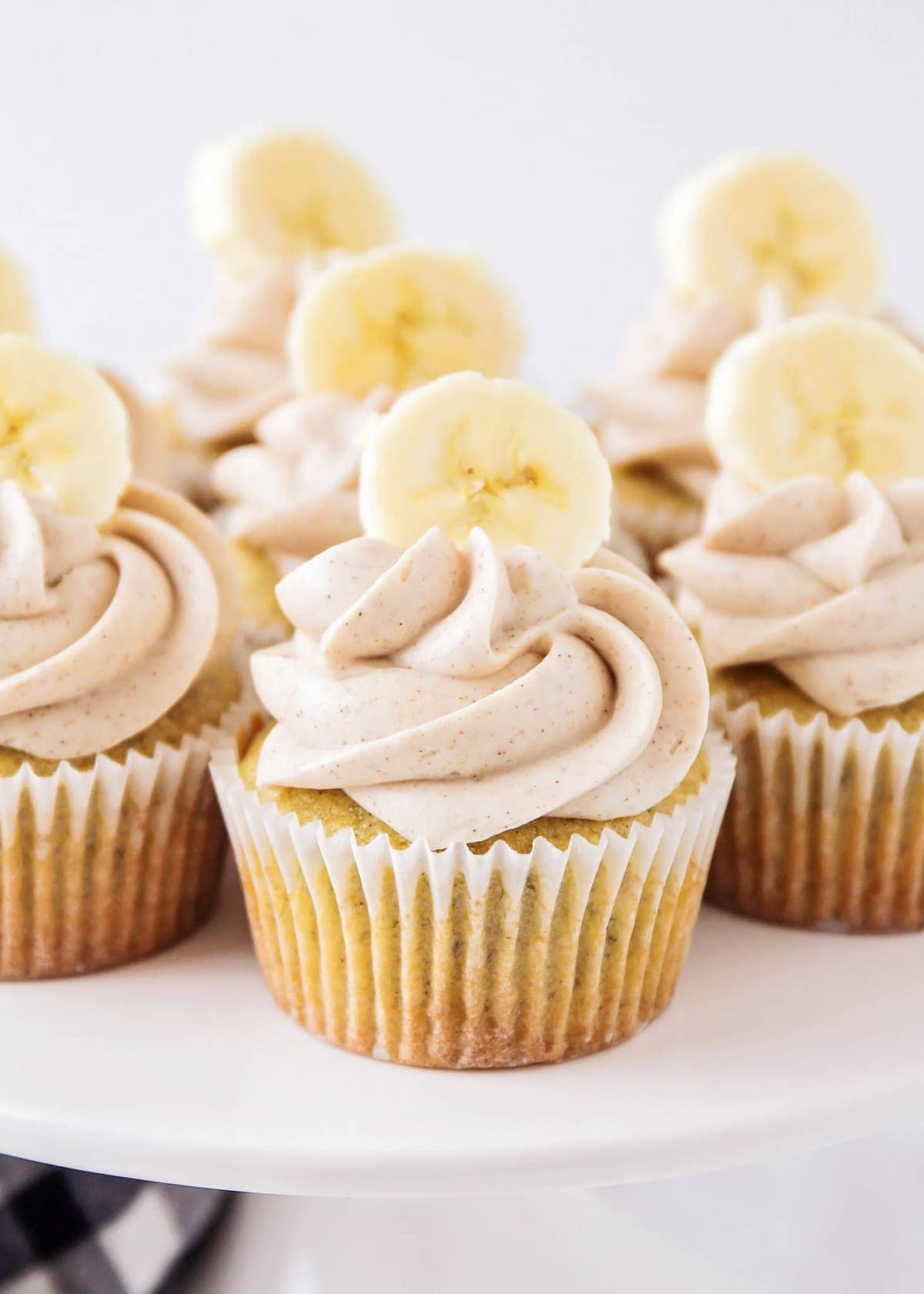 Banana cupcakes with cream cheese frosting on a cake stand