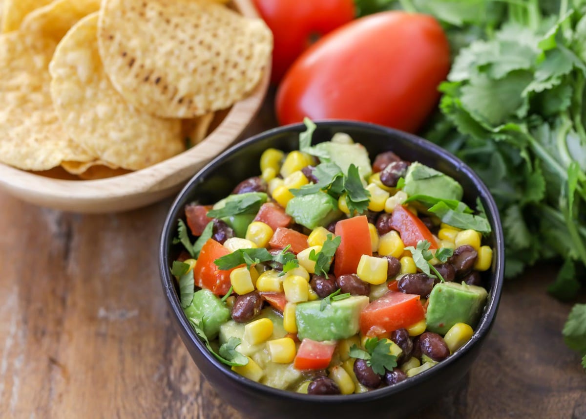 Pineapple salsa - black bean and corn salsa served in a black bowl.