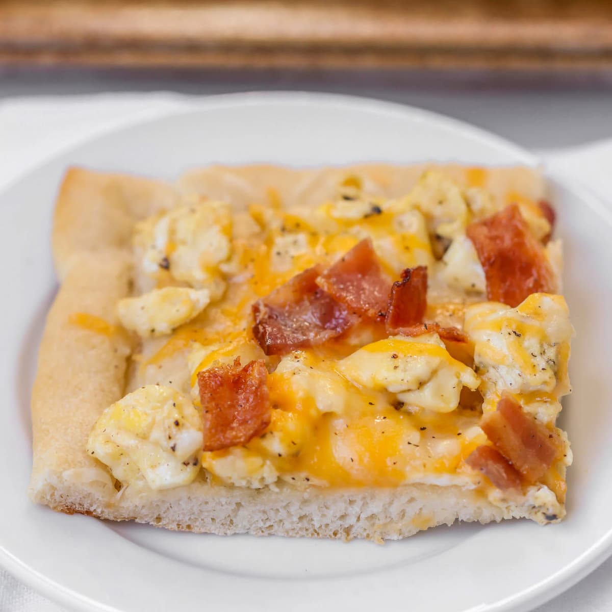 A slice of Bacon Breakfast Pizza on plate.