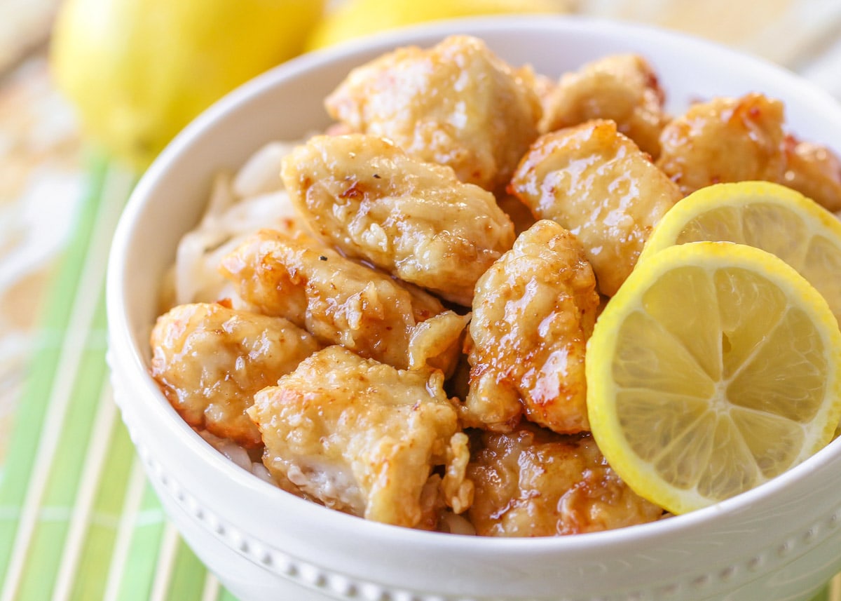 Asian Dinner Recipes - Chinese lemon chicken with two lemon slices in a white bowl. 