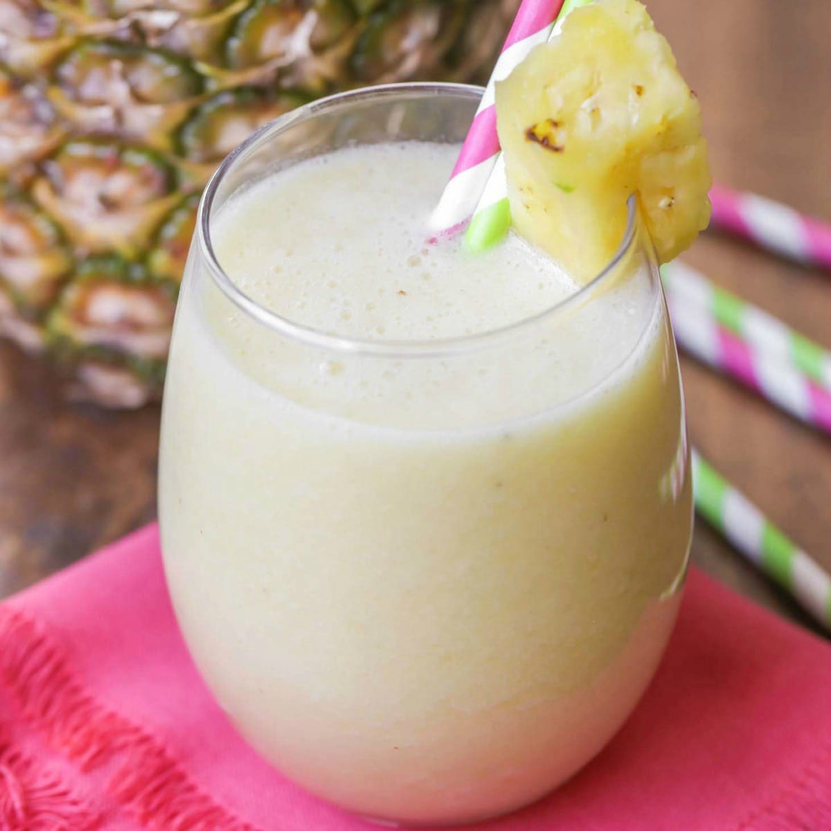 Short glass of Pineapple Banana Smoothie with a pineapple garnish.