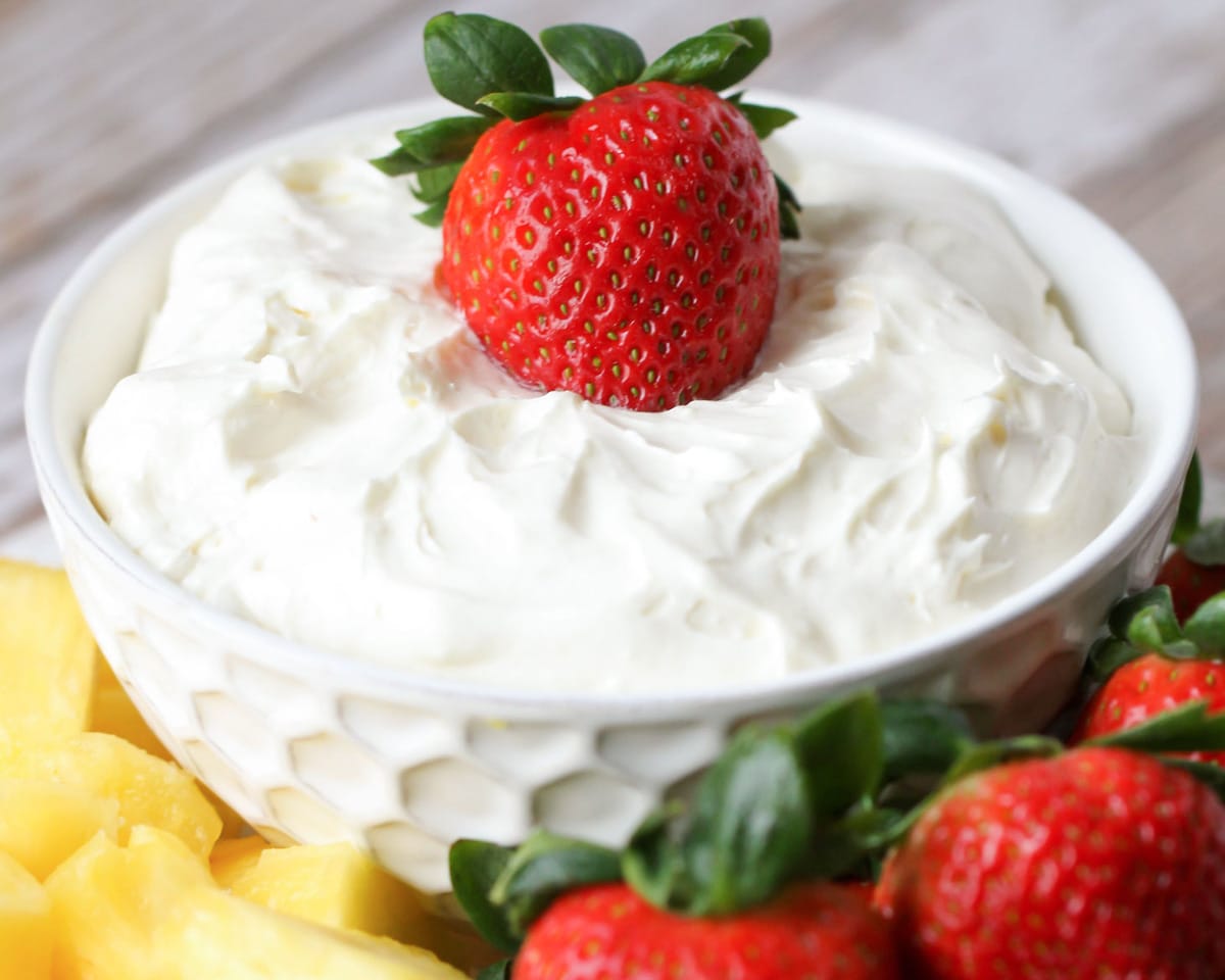 Vanilla yogurt fruit dip served with strawberries and pineapple on the side.