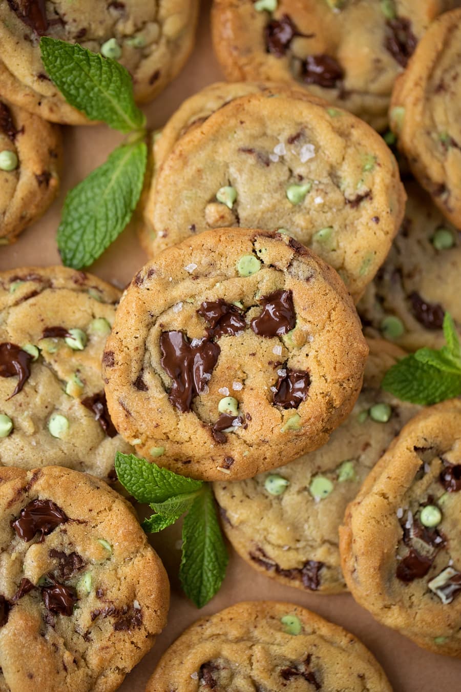 mint chocolate chip cookies stacked on a baking sheet