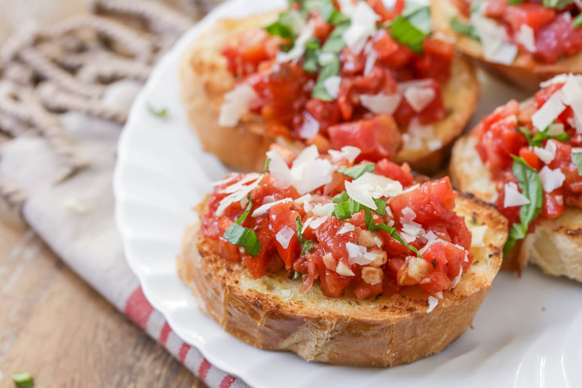 Sliced bruschetta on a white plate for an appetizer.