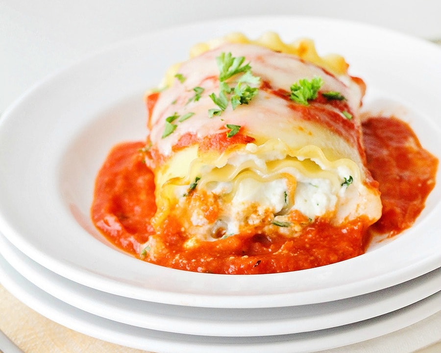 Spinach Lasagna Rolls served on a white plate garnished with fresh parsley.