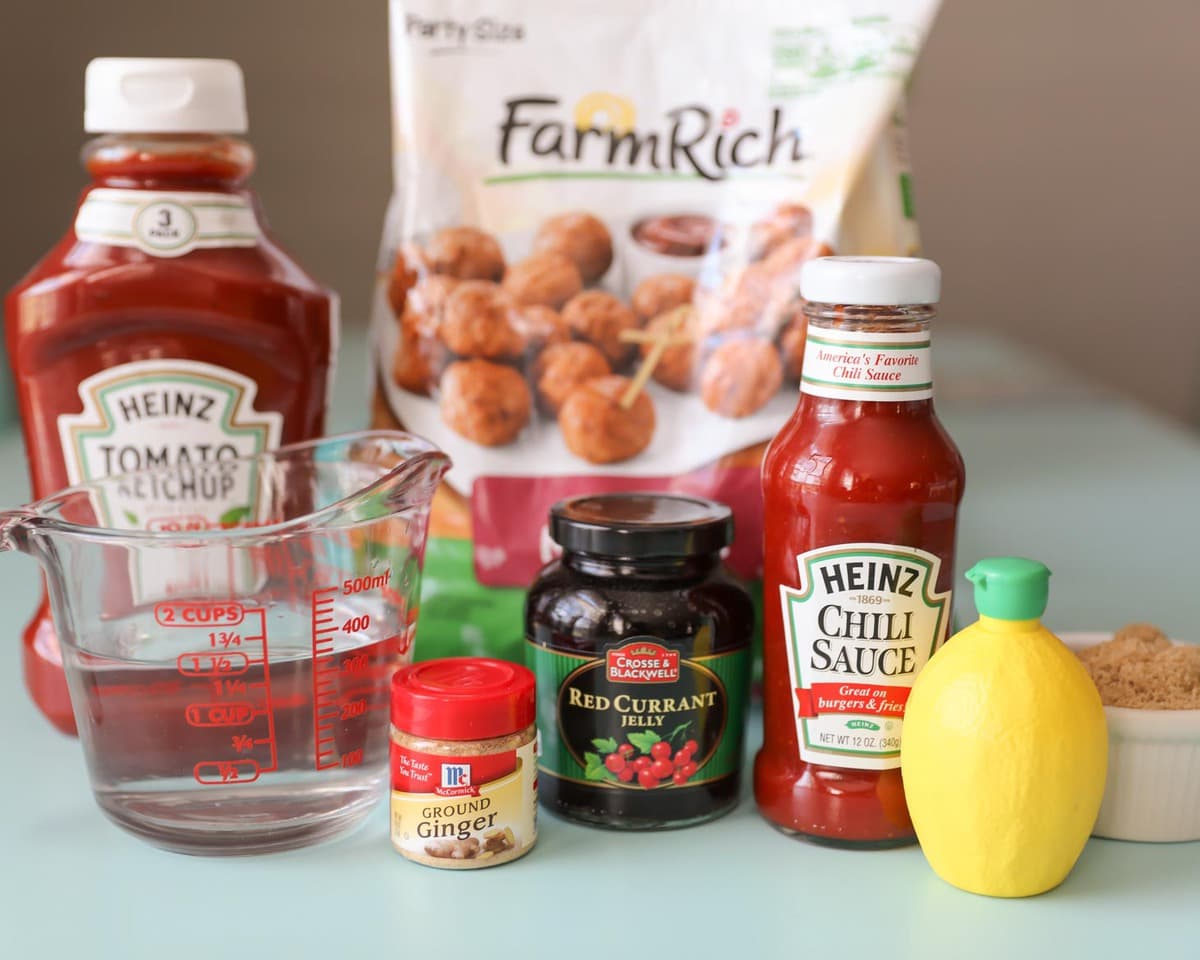 Frozen meatballs, ketchup, and other seasonings out on a kitchen counter.