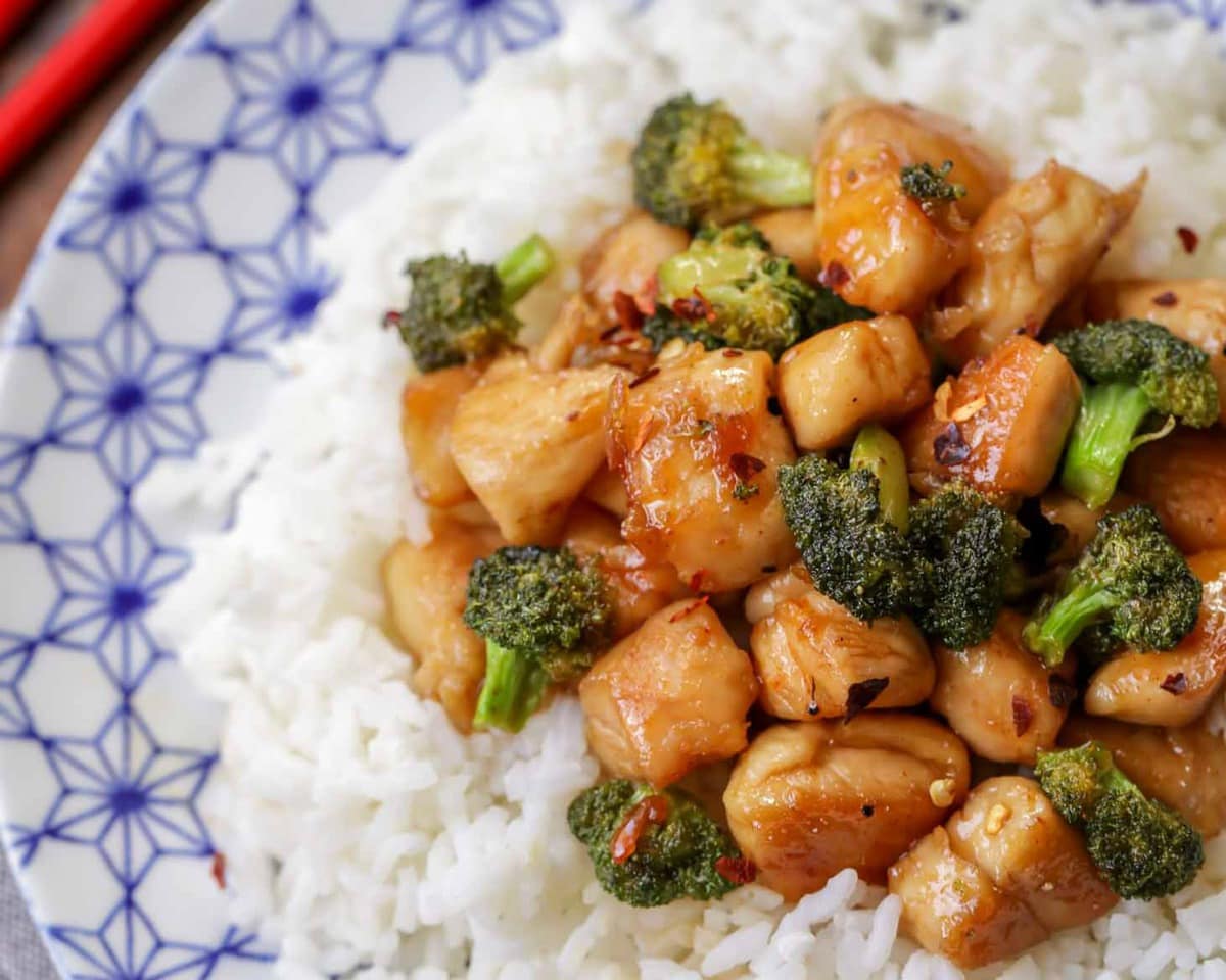 Asian Dinner Recipes - Honey Chicken with broccoli on top of white rice on a blue and white plate. 