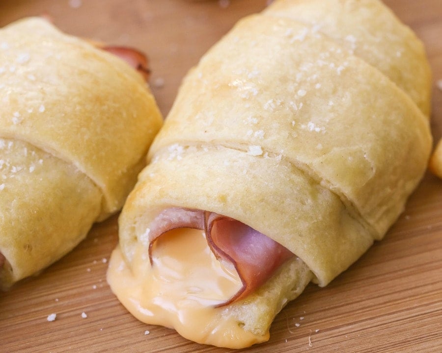 hot ham and cheese roll ups on a wooden table